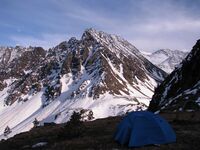 Рисунок 28 Лагерь над обрывистым берегом долины р. Левой Билюты. В правой части фото, на заднем плане виден перевал Байконур